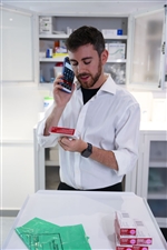 hc50-apotheker-aan-de-telefoon-kijkt-naar-medicatielabel